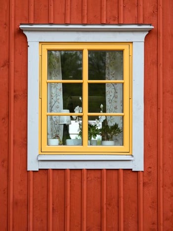 Röd fasad med gult gammaldags fönster