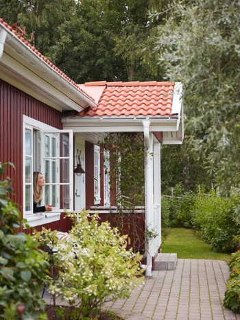 Rött hus med vita knutar med gammaldags fönster